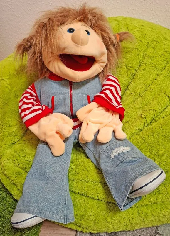 Eine Praxispuppe macht es sich im grünen Plüschsitzkissen gemütlich Eine Praxispuppe macht es sich im grünen Plüschsitzkissen gemütlich