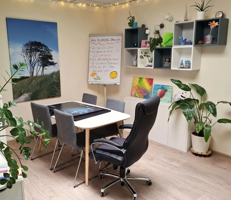 Tisch mit 4 Stühlen und einem Chefsessel im Wartezimmer