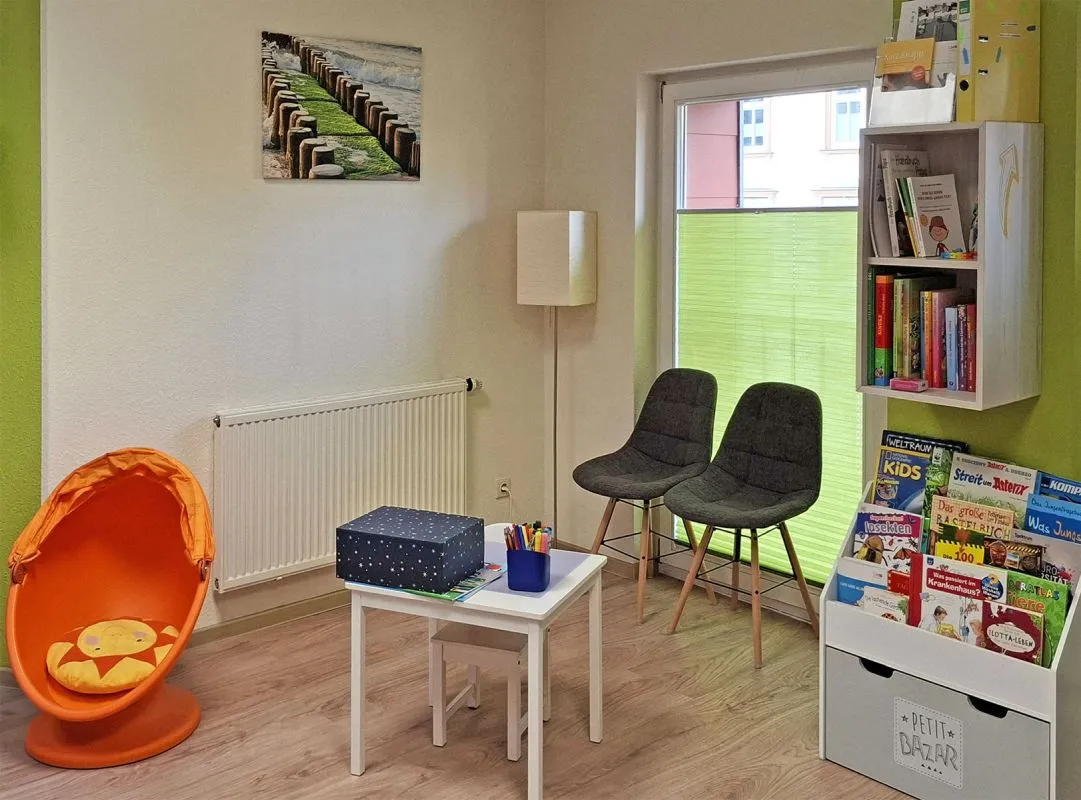 Kinder-Maltisch mit Stiften und Kinderbuchständer im Wartebereich